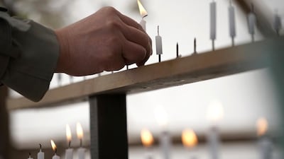A man lights a candle for victims of the March 11, 2011 earthquake and tsunami prior to a special memorial event in Tokyo, Japan, on March 11, 2018. Eugene Hoshiko / AP