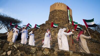Journey of the Union participants raise the flag after stopping at the Emirate’s oldest fort and mosque at Fujairah. Lee Hoagland / The National