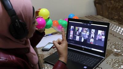 This picture taken on March 23, 2020 shows Palestinian teacher Jihad Abu Sharar presenting an online class from her home in the village of Dura near Hebron in the occupied West Bank, after schools were closed as a preventive measure against the spread of the COVID-19 novel coronavirus. / AFP / Hazem BADER