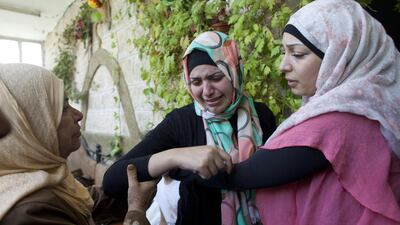 Mohammed Abu Khudair's cousin Ansam, (centre) cries as police fire stunt grenades outside the home in the Arab neighborhood of Shuafat, an Arab neighborhood of Jerusalem nearby the home of Mohammed Abu Khudair, 16. Heidi Levine for The National