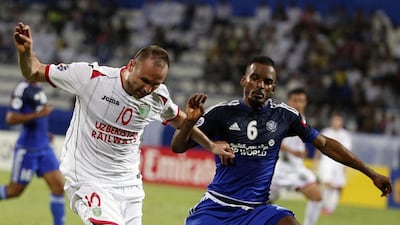 UAE’s Al-Nasr club player Mahmoud Khamis (R) and Uzbekistan’s Lokomotiv club player Mart Bikmaev vie for the ball during their Asian Champions League (AFC) group A football match at the Rashid Al-Maktoum Stadium in Dubai on April 20, 2016. / AFP / KARIM SAHIB
