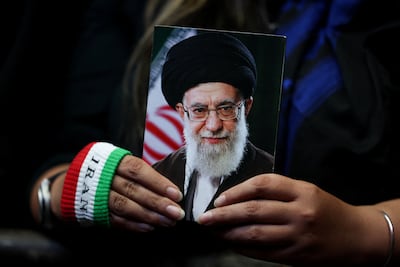 A woman holds an image of late Iranian supreme leader Ayatollah Ali Khamenei during a rally in Tehran. Reuters