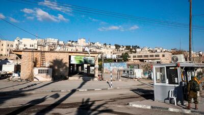 An Israeli soldier stands by an army checkpoint opposite an old market building along al-Shuhada street in the flashpoint city of Hebron in the occupied West Bank. AFP
