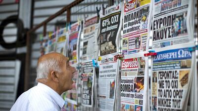 A man looks at the newspapers at a stand in central Athens. Emilio Morenatti / AP Photo