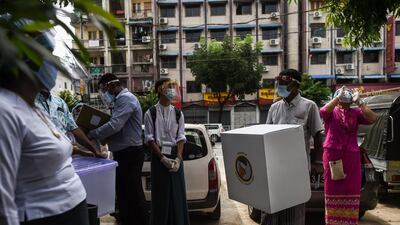 Election staff carry a mobile ballot box in Yangon last week, as advance voting in the country's election began for elderly people. AFP