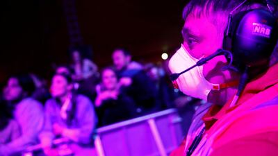 A staff member wearing a face mask looks on at the crowd. Reuters