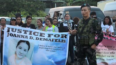 Relatives of Filipina worker Joanna Demafelis, whose body was found inside a freezer in Kuwait, hold banners as they wait for the arrival of Joanna's body from Manila at Iloilo International Airport in Iloilo province, central Philippines, on February 17, 2018. AFP