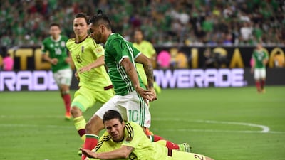 Mexico’s Jesus Manuel Corona eludes Venezuela’s Wilker Romero to score. Nelson Almeida / AFP