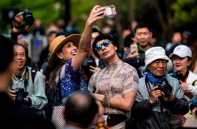 A couple poses for a selfie as they arrive at the Shanghai Fashion Week late last month. AFP