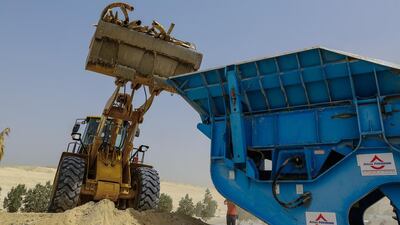 A bulldozer picks up sacks of illegal ivory before getting picked up by a bulldozer to be put into a crushing machine and destroyed. Victor Besa for The National.