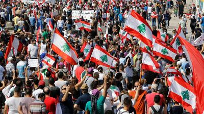 Protesters wave Lebanese national flags as they shout slogans against the government. AP