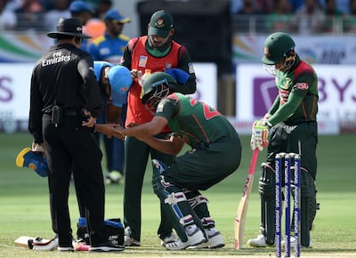 Bangladesh's Tamim Iqbal receives medical assistance after fracturing his wrist against Sri Lanka. AFP