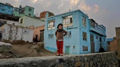 An Afghan girl walks on a wall in Kabul, Afghanistan. AP Photo