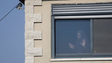 A Palestinian woman looks from a window in Qusra village. Reuters