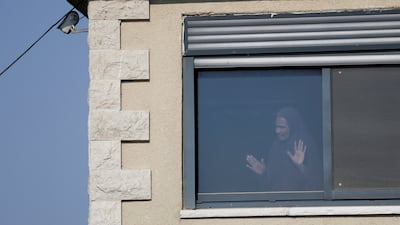 A Palestinian woman looks from a window in Qusra village. Reuters
