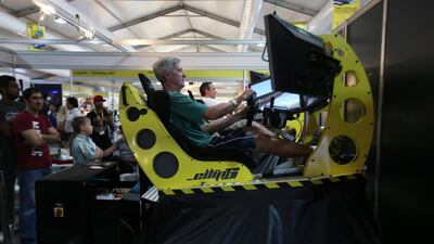 Visitors try a driving simulator at the 2014 Big Boys Toys show. Pawan Singh / The National
