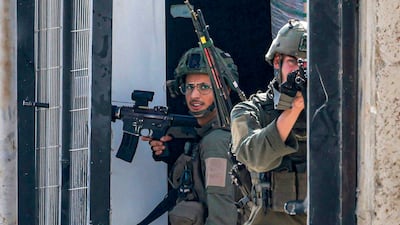 An Israeli soldier takes aim in the West Bank city of Tulkarm on Friday. UN Secretary General Antonio Guterres has called for an immediate halt to Israel's military operation. AFP