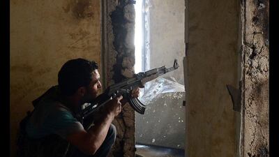 On the look out: a Syrian rebel keeps a close eye out during clashes with government forces in the Saif al-Dawla district of the northern city of Aleppo. Tauseef Mustafa / AFP