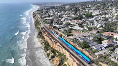An aerial view of a Coaster commuter train passing along eroding cliffs at the Pacific Ocean coastline in Del Mar, California. Getty Images