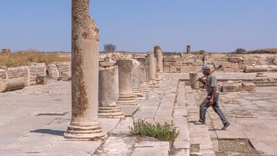 A worker walks through the ruins of Makhtar, a three-hour drive from the Tunisian coast, where there are no tourists anywhere to be seen. Sebastian Castelier for The National