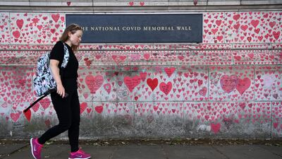 A member of the public walks past the Covid-19 Memorial Wall in London. EPA