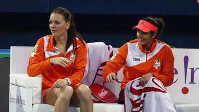 Indian Sania Mirza (R) and Agnieszka Radwanska of Micromax Indian Aces cheer during a tennis match between France’s Fabrice Santoro of Micromax Indian Aces and Sweden’s Thomas Engvist of Legendari Japan Warriors during the part of the International Premier Tennis League (IPTL) on December 14, 2015 in the Emirate Dubai. AFP PHOTO / KARIM SAHIB