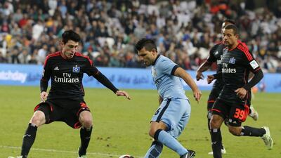 Manchester City Sergio Aguero dribbles past Hamburg defenders Sven Mende, left, and Ashton Gotz during their friendly match in Al Ain on Wednesday. Karim Sahib / AFP