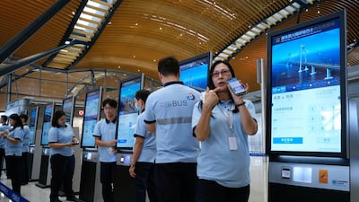 A staff worker demonstrates how to use the ticket machine. AP Photo