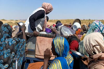 Refugees from the city of El Fasher receive food at a Sudanese refugee camp. AP