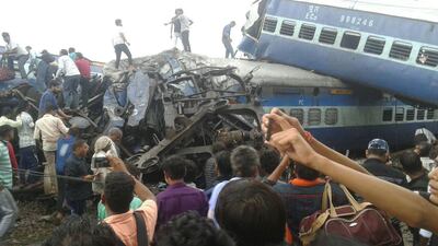 Railway police and local volunteers look for survivors in the upturned coaches of the Kalinga-Utkal Express. The Associated Press