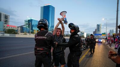 Israeli police officers disperse demonstrators blocking a highway during a protest in Tel Aviv on Saturday. AP