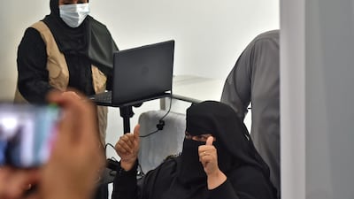 A woman celebrates becoming the first female Saudi citizen receiving the Pfizer-BioNTech COVID-19 coronavirus vaccine. AFP