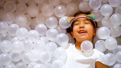 A young girl is covered in plastic balls at a shopping mall in Bangkok, Thailand. EPA