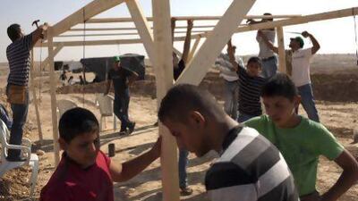 Bedouins build a makeshift house in Al Araqib, a Bedouin village in the Negev Desert as they mark one year since its destruction by Israeli authorities.