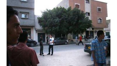 Locals in Misurati Street, in Tripoli's Abu Slim district. Youssef and Abdelkarim el Hazali were shot dead beneath the tree in the background last month by NTC fighters. (John Thorne / The National)