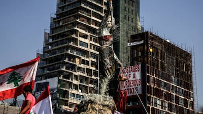 A statue called 'Life from Rubble' created by artist Hayat Al Nazer is displayed in front of a destroyed building at Beirut port on the anniversary of the explosion. Picture Alliance via Getty Images