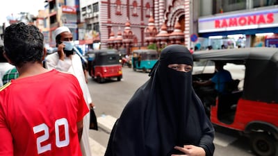 A woman walks along a street of Colombo, Sri Lanka. The Sri Lankan government said it will ban garments worn by some Muslim women that cover the body and face. AP Photo