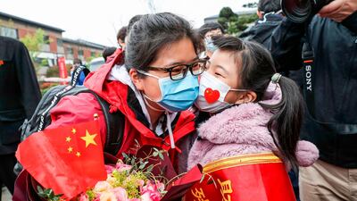 A member of a medical assistance team from Huaian being welcomed by her daughter after returning home from Wuhan to help with the COVID-19 coronavirus recovery effort in Huaian in China's eastern Jiangsu province. AFP