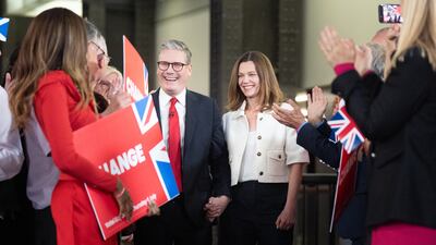 Mr Starmer and his wife, Victoria, are applauded by supporters. PA