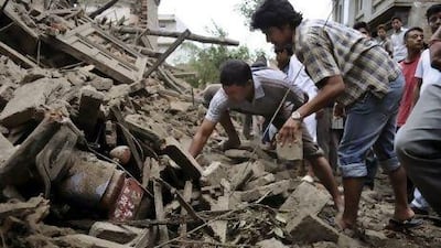 People try to take out a motorbike buried under the debris of a house damaged by Sunday's earthquake in Bhaktapur about 14 kilometers from Katmandu, Nepal. AP