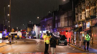 A person speaks with a police officer who stands guard at the scene. Reuters