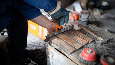 Strips of scrap steel are clamped together before being welded to make body armour for bulletproof vests and flak jackets.