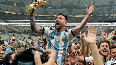 FILE - Argentina's Lionel Messi celebrates with the trophy in front of the fans after winning the World Cup final soccer match between Argentina and France at the Lusail Stadium in Lusail, Qatar, Sunday, Dec. 18, 2022. Lionel Messi has been named FIFA’s best men’s player after moving to Inter Miami and leading the team to a little-known Leagues Cup title, all while single-handedly elevating soccer’s relevance in the United States. The 36-year-old Argentina star on Monday was selected over Kylian Mbappe and Erling Haaland — the same pair he beat for his eighth Ballon d’Or award last October. (AP Photo / Martin Meissner, File)