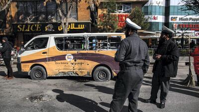 Security forces stand outside Slice Bakery in Share-Naw, where one of the rockets hit, damaging a delivery van and injuring several people. Stefanie Glinski for The National