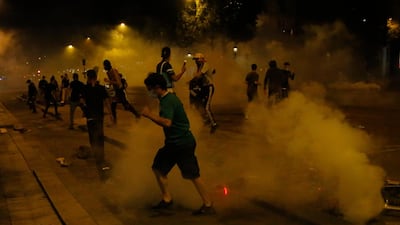 PSG supporters run through tear gas. AP