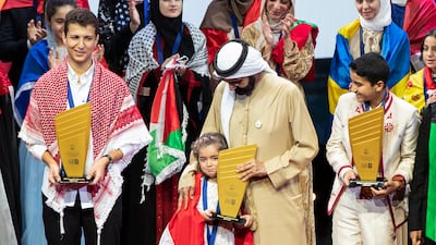 Sheikh Mohammed with Sham Bakour, 7, a Syrian schoolgirl who was crowned Arab Reading Challenge champion in Dubai. Sham survived a deadly missile attack during the civil war in her country. Ruel Pableo for The National