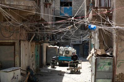 Electrical wires, emblematic of Iraq's struggle for a reliable supply of power, hang between buildings in a street in Baghdad on July 13. AFP