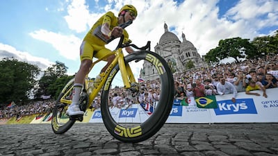 Tadej Pogacar rides past the Sacre Coeur basilica en route to winning his fifth Tour de France title. AFP