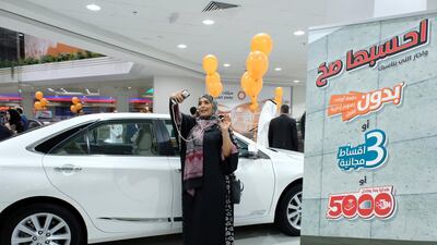 Pink, orange and yellow balloons hung in the mall's showroom as women posed for photos and selfies in front of vehicles.