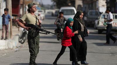 A Turkey-backed Syrian rebel fighter patrols in the border town of Tal Abyad, Syria. Reuters